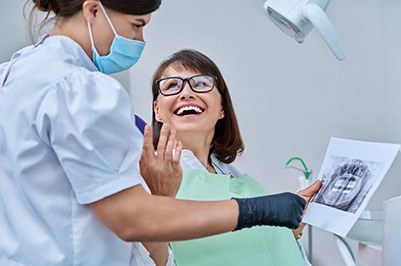 Dentist reviewing X-ray with smiling patient