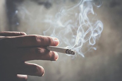 Close up of a hand holding a cigarette