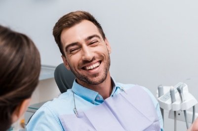 Man smiling in dental office with advanced patient safety protocols