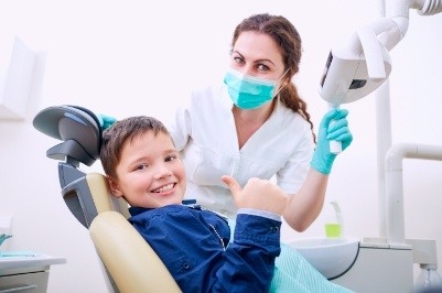 Child giving thumbs up at first visit