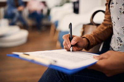 Woman holding blue clipboard with forms to fill out
