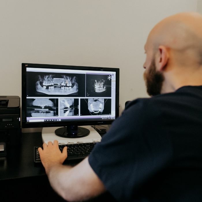 Doctor Moaz Zanbarakji looking at dental x-rays on computer
