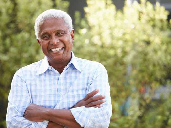 Man smiling with blurred outdoor background