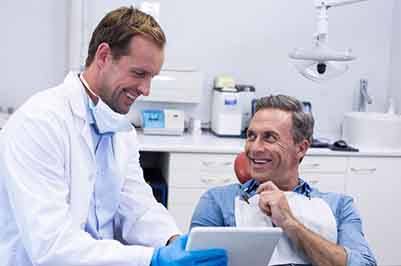 Dentist and patient smiling during consultation