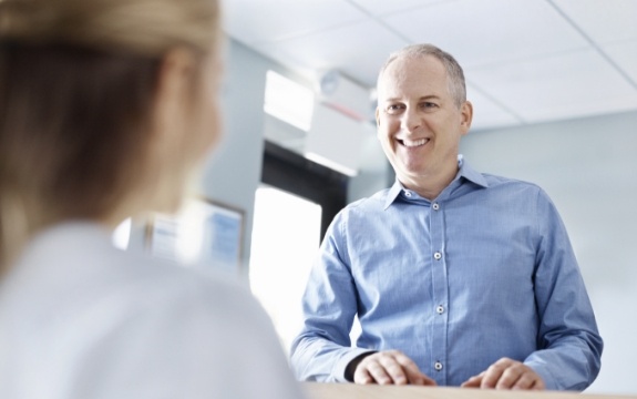 Man discussing his payment options with dental team member
