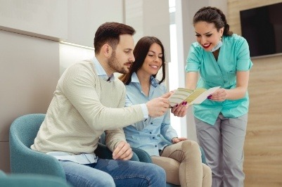 Dental team member discussing how dental insurance works with two patients