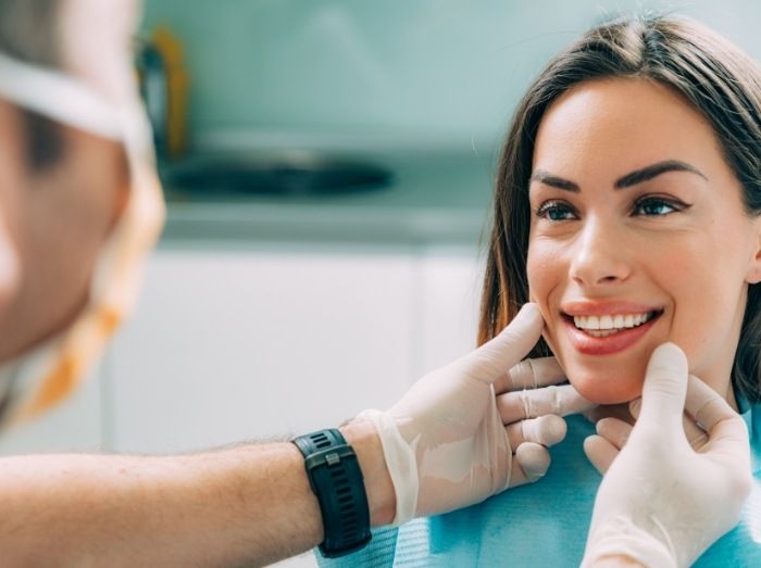 Dentist examining woman's smile after teeth whitening
