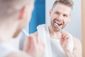 young man brushing his teeth