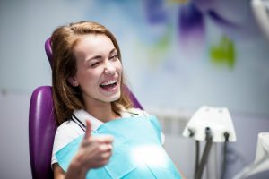 young woman smiling in dentist chair